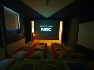 a dark room with three beds in front of a screen at Family Friendly Funhouse Centrally Located in Ottensen in Hamburg