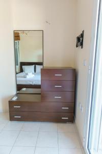 a bedroom with a dresser with a mirror on it at Mansion in Peraia by thesbnb in Perea