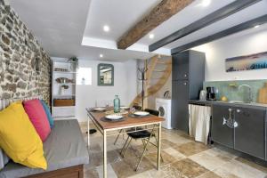 a living room with a table and a kitchen at La Quinardais - Charmante maison avec terrasse in Saint-Samson-sur-Rance