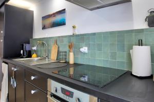 a kitchen with a sink and a counter top at La Quinardais - Charmante maison avec terrasse in Saint-Samson-sur-Rance