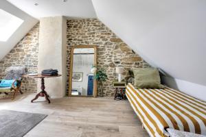 a bedroom with a bed and a mirror at La Quinardais - Charmante maison avec terrasse in Saint-Samson-sur-Rance