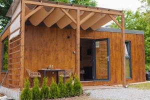 un capanno di legno con tenda da sole e tavolo di Tiny Heaven Cabin a Călimăneşti