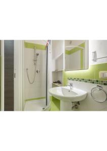 uma casa de banho com um lavatório e um chuveiro com um espelho. em Casa Cinisi - Casa Vacanze em Cinisi