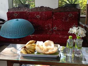 a table with a plate of food on top of a couch at 152-Abhaya Place Homestay in Talalla