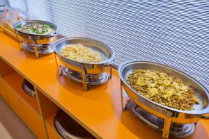 three pans of food sitting on a counter at Yung An Business Hotel in Dounan