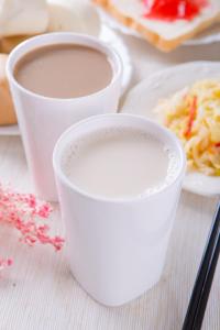 two cups of milk and a plate of food at Yung An Business Hotel in Dounan
