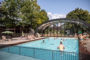 un gruppo di persone che nuotano in piscina di Huttopia Les Châteaux a Bracieux