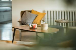 a coffee table with two cups and a couch at Property with heated pool near Deauville in Saint-Étienne-la-Thillaye
