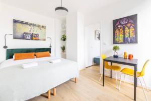 1 dormitorio con 1 cama, mesa y sillas en LIK APPARTS MABILAY en Rennes