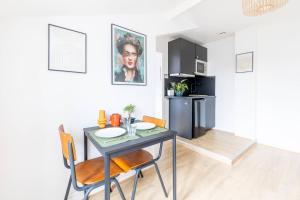 een keuken en eetkamer met een tafel en stoelen bij LIK APPARTS MABILAY in Rennes