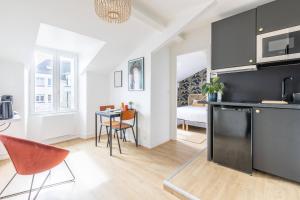 a kitchen and living room with a table and chairs at LIK APPARTS MABILAY in Rennes