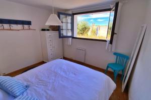 Un dormitorio con una cama azul y una ventana en Gîte Pachamama, en Cayeux-sur-Mer