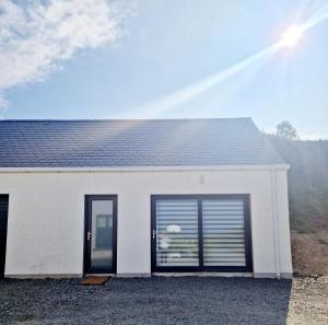 a white house with a window and a roof at Sea View Studio in Buncrana