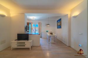 a living room with a television and a table at Porto Rotondo Central House in Porto Rotondo