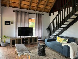 a living room with a blue couch and a television at Acoustic Guest House in Pretoria