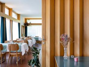 Chez Elsy - Crans-Sapins في كرانس مونتانا: مطعم به طاولات وكراسي و إناء من الزهور