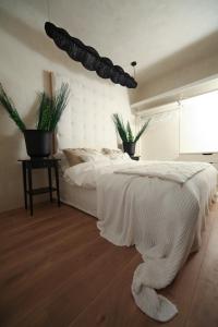1 dormitorio con 1 cama con colcha blanca en Strelnieku Avenue Apartment Jurmala, en Jūrmala