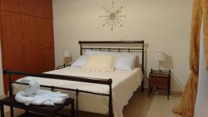 - une chambre avec un lit et une horloge murale dans l'établissement Tholos Bay Suites, à Kavoúsion