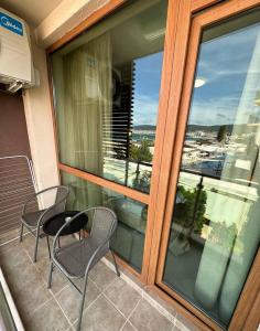 a balcony with two chairs and a table and a window at Briz Beach apartments - section B in Sunny Beach