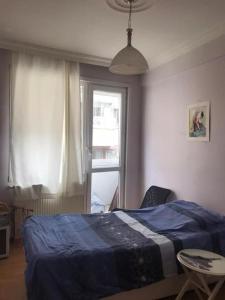 a bedroom with a bed and a table and a window at Bright apartment in Beşiktaş / Abbasağa in Istanbul