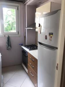 a kitchen with a refrigerator and a stove and a window at Bright apartment in Beşiktaş / Abbasağa in Istanbul
