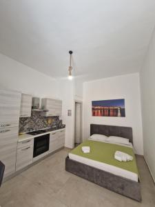 a bedroom with a large bed and a kitchen at AP Apartment - in centro! in Gallipoli