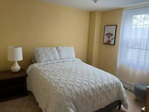 a bedroom with a bed with a white comforter and a window at Spacious & Peaceful Home in the heart of Sheboygan in Sheboygan