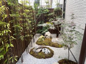 a garden with rocks and trees and a fence at YADO TENKU Kyoto Nijo in Kyoto