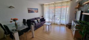 sala de estar con sofá púrpura y mesa de cristal en Miramar Serveis - La LLosa, en Cambrils