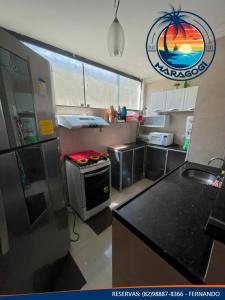 een keuken met een koelkast en een fornuis top oven bij Flat Residence Maragogi in Maragogi