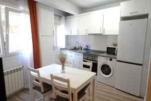 a kitchen with a white table and a white refrigerator at Vacare centro de Santander in Santander