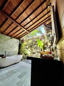 un bagno con vasca e lavandino di Aix Cottage Ubud ad Ubud