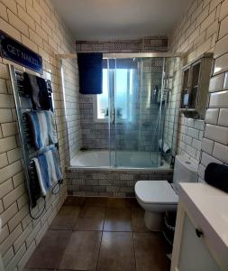 ein Bad mit einer Badewanne, einem WC und einer Dusche in der Unterkunft Benahavis Village Penthouse Apartment, 2 Bedrooms, Stunning Views, Swimming Pool !! in Benahavís