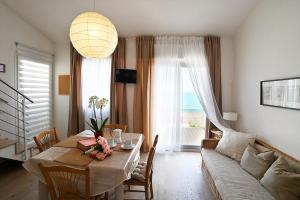 ein Wohnzimmer mit einem Tisch und einem Sofa in der Unterkunft Conero Casa - Marcelli di Numana in Via Litoranea 101 in Marcelli