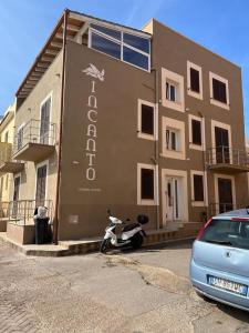 un edificio con una moto aparcada delante de él en Incanto Luxury Rooms, en Lampedusa