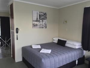 um quarto com uma cama com uma fotografia na parede em North End Motel em Huntly