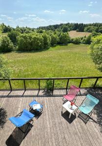 twee stoelen en een tafel op een terras met een veld bij Szarejkowe Wzgórza in Szarejki