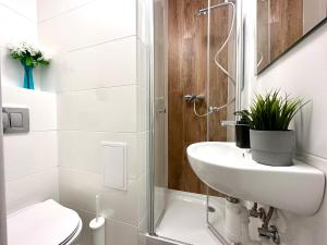 een badkamer met een wastafel, een toilet en een douche bij MMRent One Way Room in Gdańsk