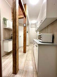 een keuken met witte kasten en een aanrecht bij MMRent One Way Room in Gdańsk
