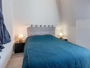 een slaapkamer met een blauw bed en 2 lampen bij Apartment Le Grand Cap-15 by Interhome in Villers-sur-Mer