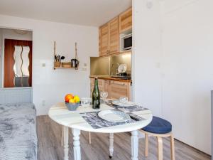 eine kleine Küche mit einem weißen Tisch und Stühlen in der Unterkunft Apartment Le Grand Cap-15 by Interhome in Villers-sur-Mer