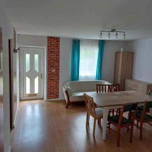 ein Wohnzimmer mit einem Tisch und einem Sofa in der Unterkunft Szary domek 1 in Wieprz