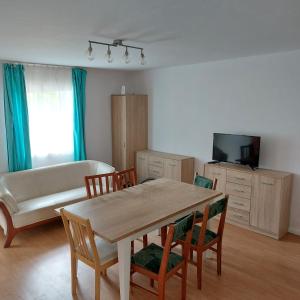 ein Wohnzimmer mit einem Tisch, Stühlen und einem Sofa in der Unterkunft Szary domek 1 in Wieprz