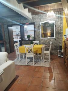 a dining room with a yellow table and chairs at Quinta Meneses in Santa Cruz