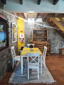 a dining room with a yellow table and white chairs at Quinta Meneses in Santa Cruz