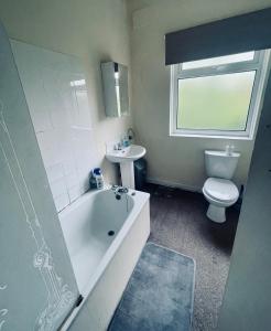 a bathroom with a tub and a toilet and a sink at A wonderful room in Sale