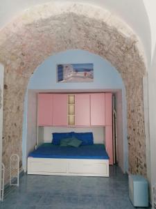 1 dormitorio con 1 cama bajo un arco en casa Aurora centro storico, en Vieste