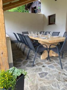 a table and chairs in a room with a stone floor at Posestvo Tmžek in Bovec