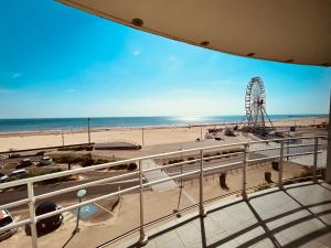 een uitzicht op een strand en een reuzenrad bij Le Miramar, face mer et standing in Saint-Jean-de-Monts