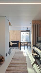 Kiigemäe maamaja : غرفة معيشة مع بيانو وغرفة طعام